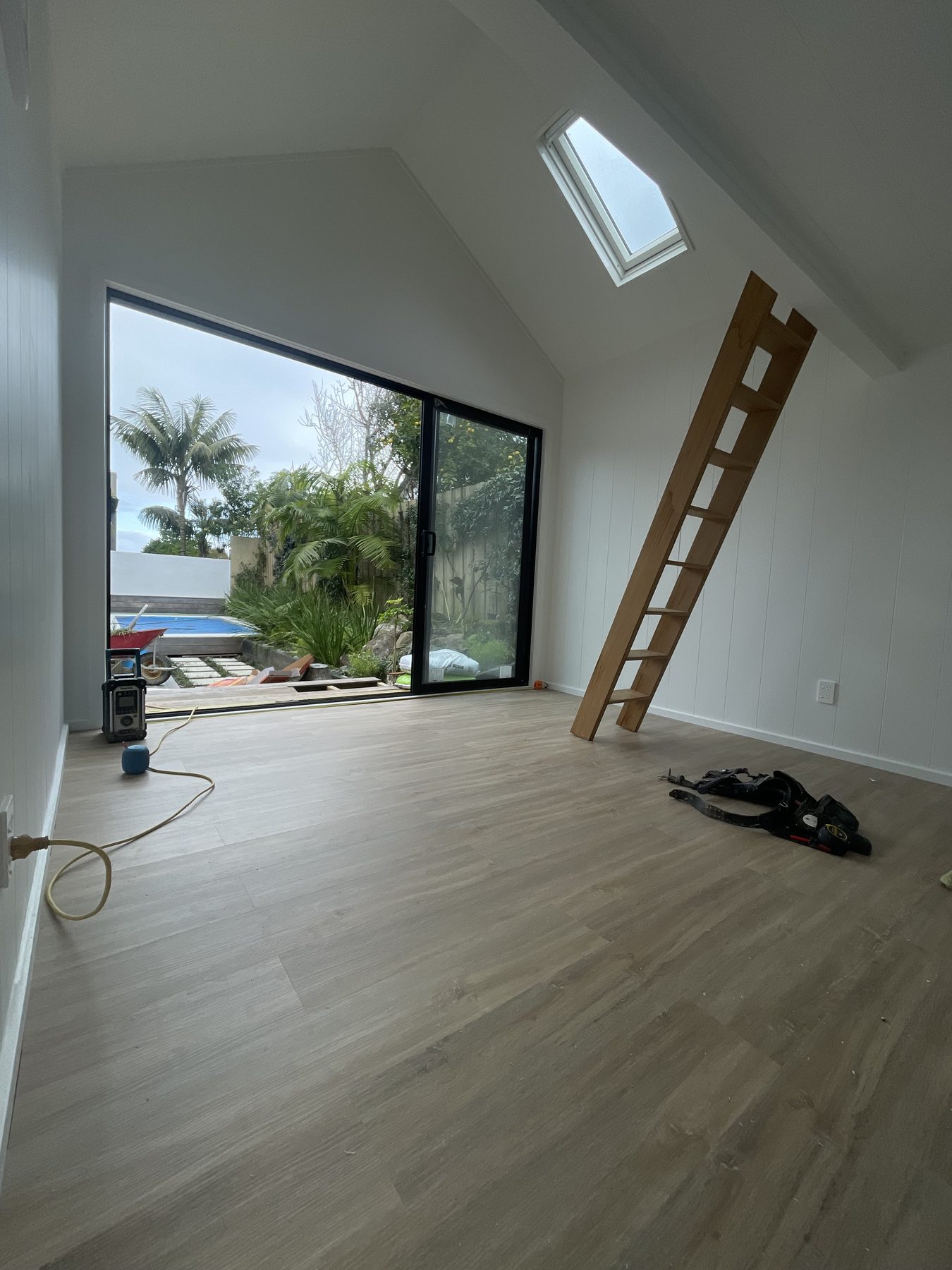Finished sleepout interior with vaulted ceiling, skylight and loft ladder