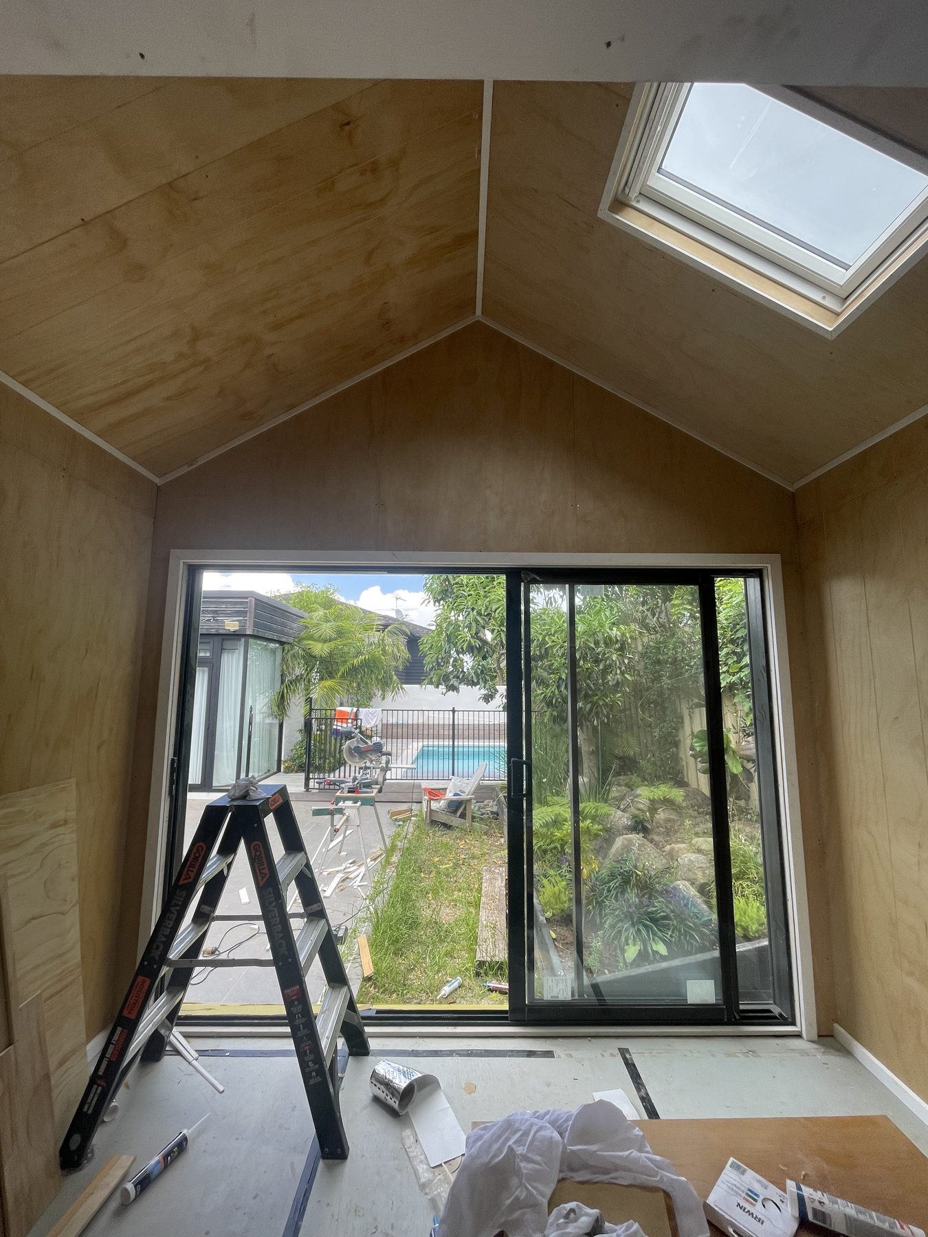 Sleepout interior lined in plywood with skylight and sliding door